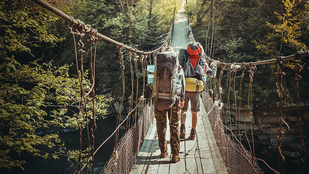 travelers crossing through hanging bridge